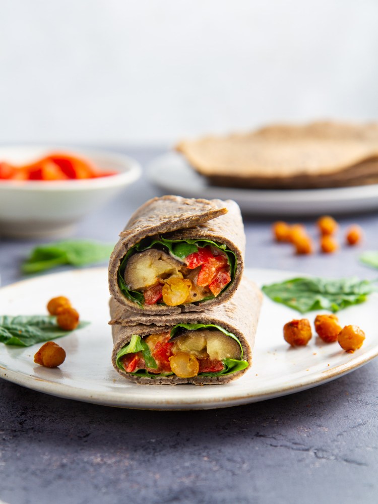 Galettes de sarrasin garnies aux pois chiches et aubergines rôtis, poivronnade, pousses d'épinards et sauce tahin-miso (vegan, sans gluten)